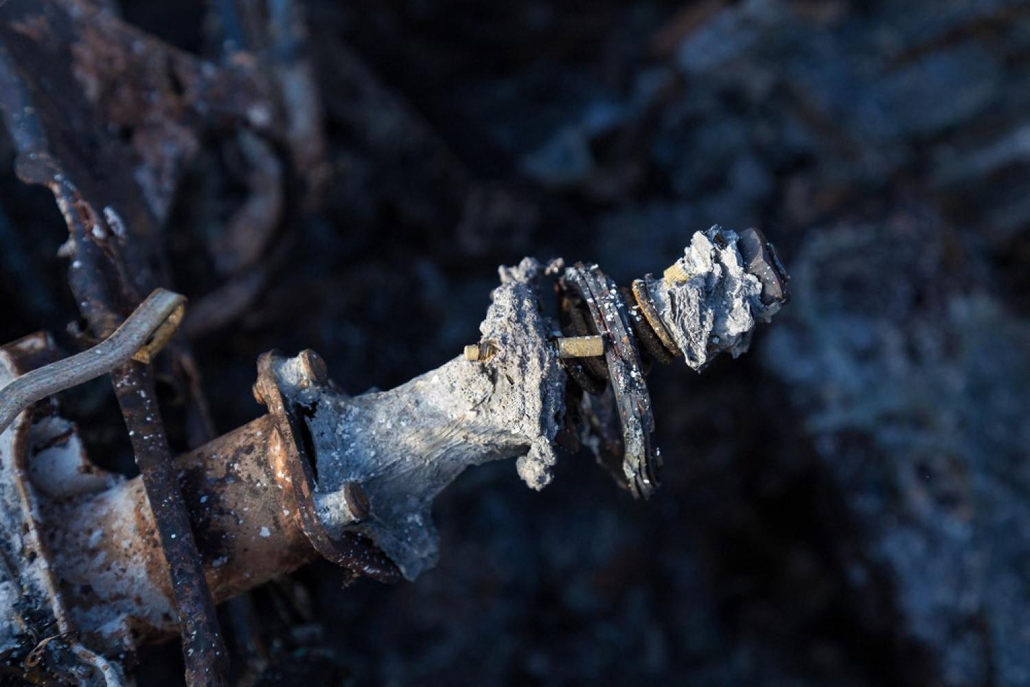 Heavily corroded suspension component with salt deposits and rust damage